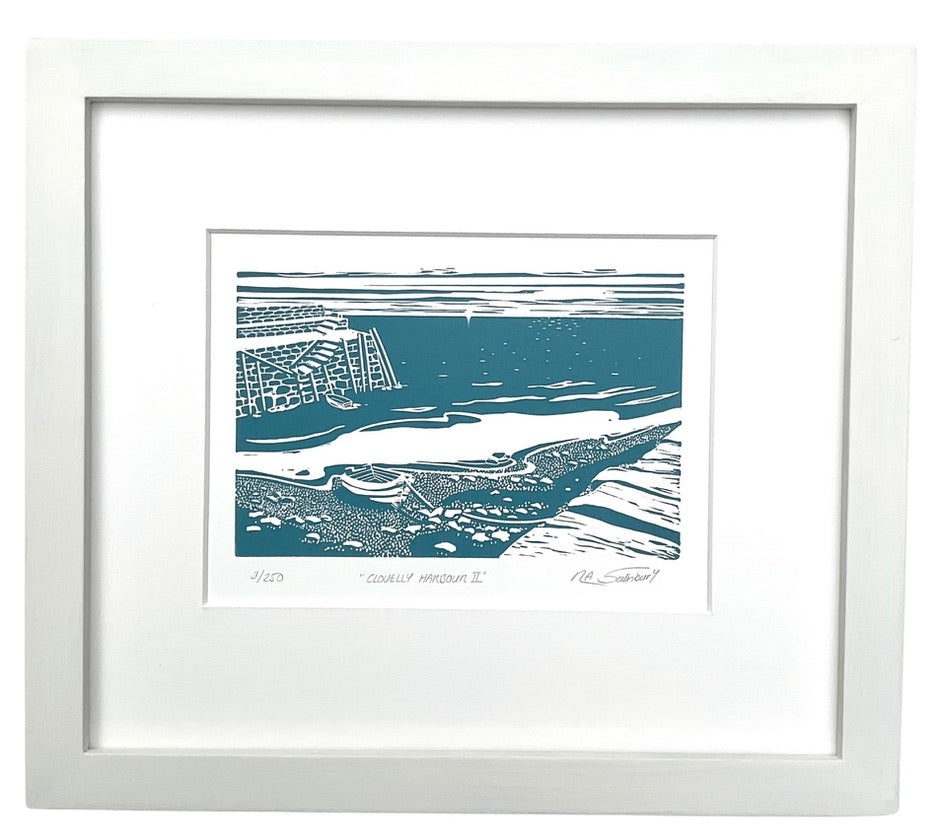 A modern style harbour and rowing boat print in bold style using a steely bluish grey and the white of the paper as its only colours. In the foreground is a stone harbour wall, a pebbly beach, a moored rowing boat and a tide lapping in. In the mid ground is the other side of the old stone harbour wall with worn steps and vertical wooden piles and another moored rowing boat. The sea sparkles with sunlight and a sky is streaked with cloud.  An off white mount and frame surround.