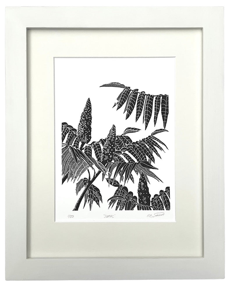 A modern style black and white print in a bold slightly tribal style showing part of a Sumac tree in close up. Three conical flower heads are shown amongst the leaves and stems.  An off white mount surrounds the print with a matching painted wooden frame.