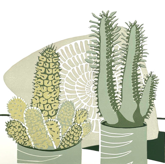 a prickly cactus in mustard, greens and greenish greys on the left and a taller euphorbia succulent in light sage green and darker greens on the right.  Both plants are in light sage green pots with a white linear design cutting in from the left side of the pot and then tapering off.  Behind is a large ammonite fossil in a greenish beige.  The design is simple and striking and uses the white of the paper as the background.